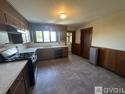 A kitchen with a stove top oven and a refrigerator.