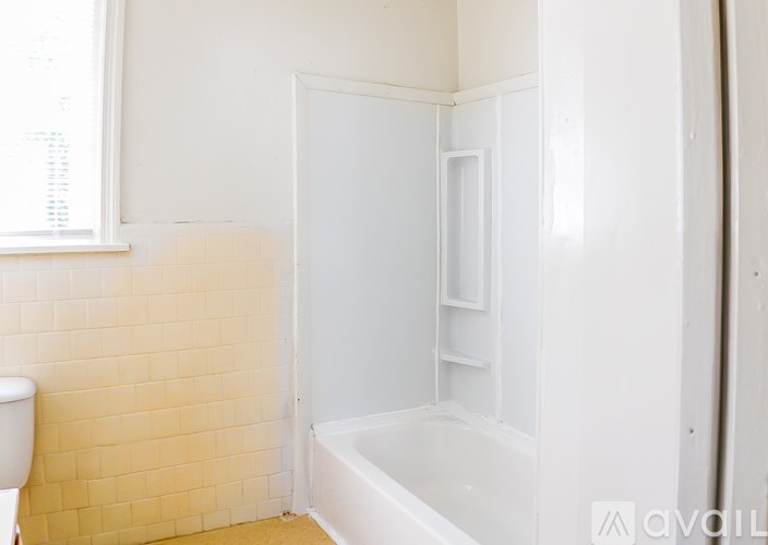 A bathroom with a tub and toilet.