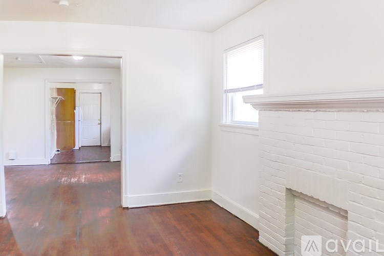 A room with a fireplace and wood flooring.