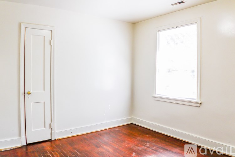 A room with a white door and a window with blinds.