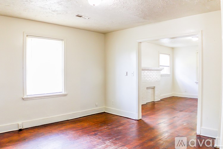 A room with a wooden floor and a window.