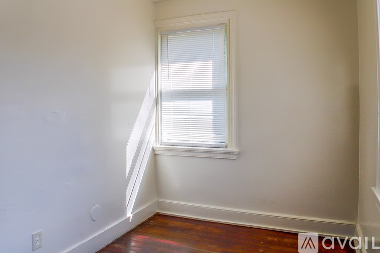 A room with a window and wooden floors.