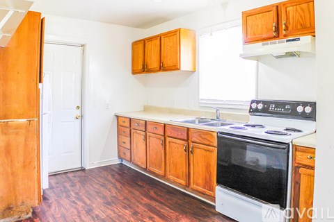A kitchen with wooden cabinets and a white stove top oven.