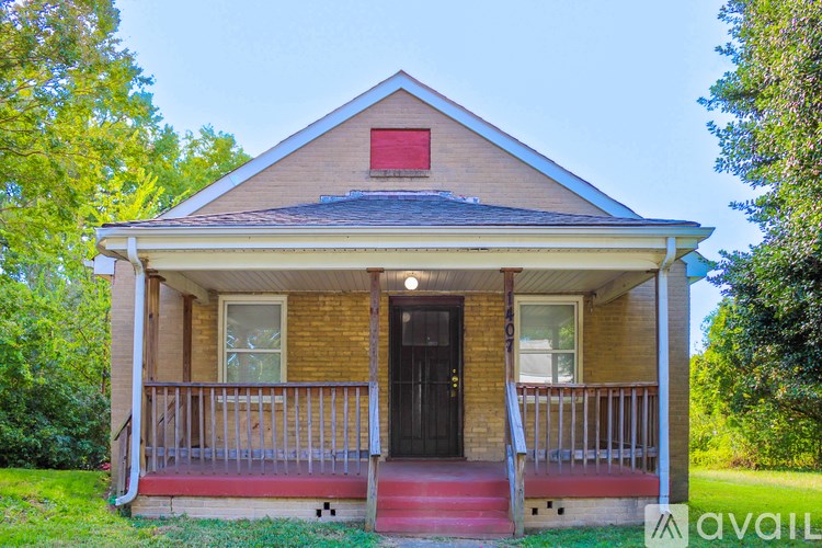 A small house with a red door and a porch.