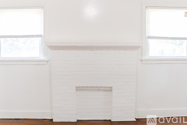 A white fireplace with a window on the left and right side.