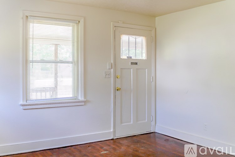 A room with a white door and a window with blinds.