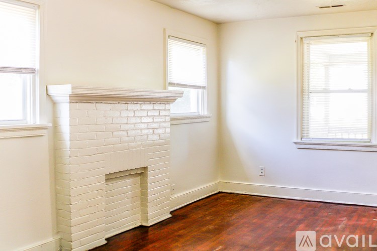 A room with a fireplace and two windows.