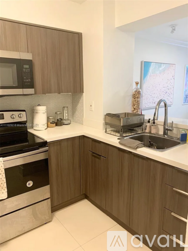 A kitchen with wooden cabinets and a stainless steel oven.
