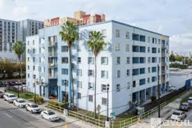 A multi-story building with a blue and white exterior and several balconies.