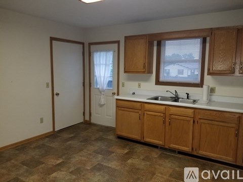 A kitchen with wooden cabinets and a tiled floor.