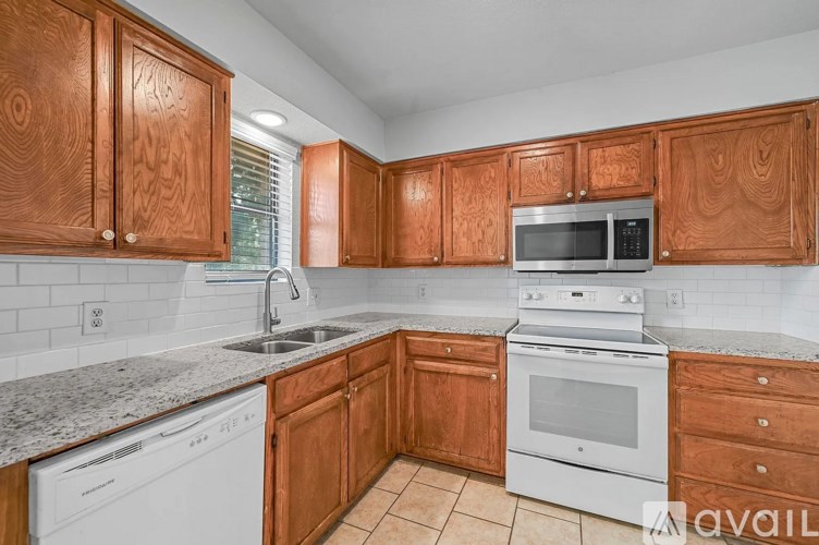 A kitchen with wooden cabinets and white appliances.