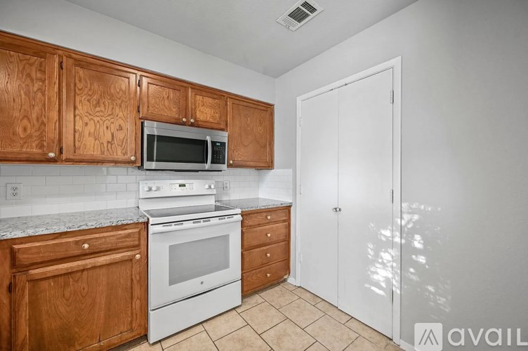 A kitchen with wooden cabinets and white appliances.