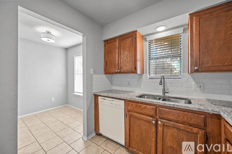 A kitchen with wooden cabinets and a white dishwasher.