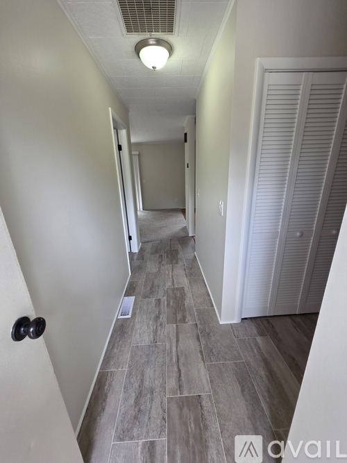A long hallway with a tiled floor and white walls.