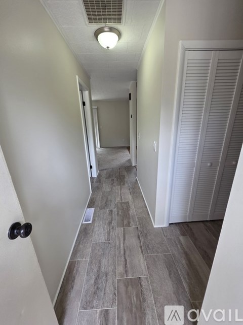A long hallway with a tiled floor and white walls.