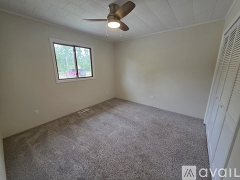 A room with a ceiling fan and a window.