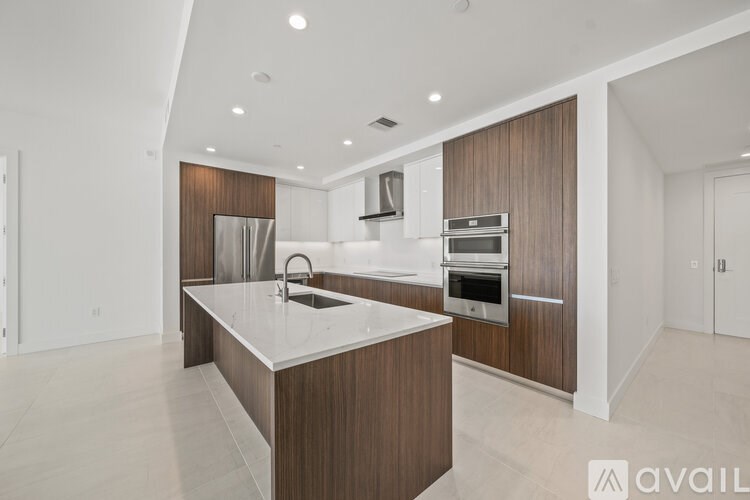 A modern kitchen with a center island and stainless steel appliances.