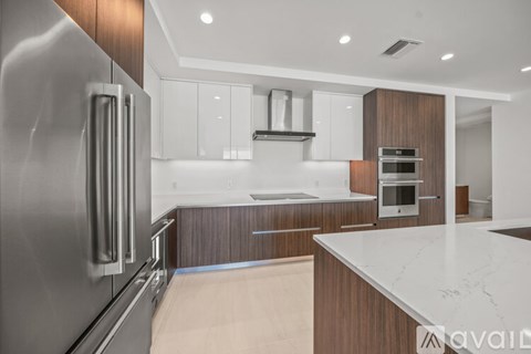 A modern kitchen with a stainless steel refrigerator and wooden cabinets.