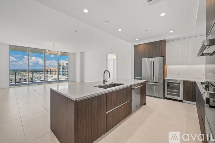 A modern kitchen with a large island and stainless steel appliances.
