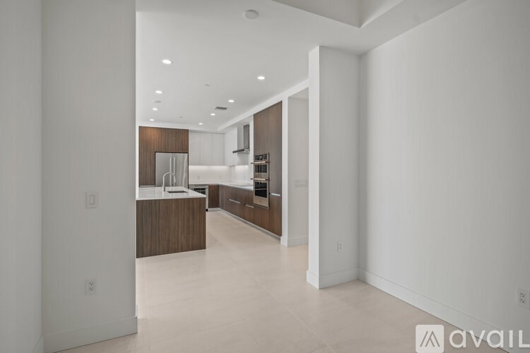 A modern kitchen with white walls and wooden accents.