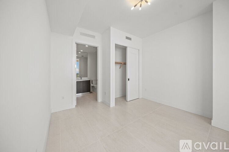 A spacious room with two open doors leading to other rooms.