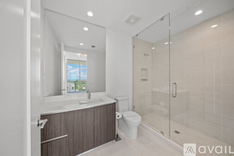 A modern bathroom with a walk-in shower and a large mirror.