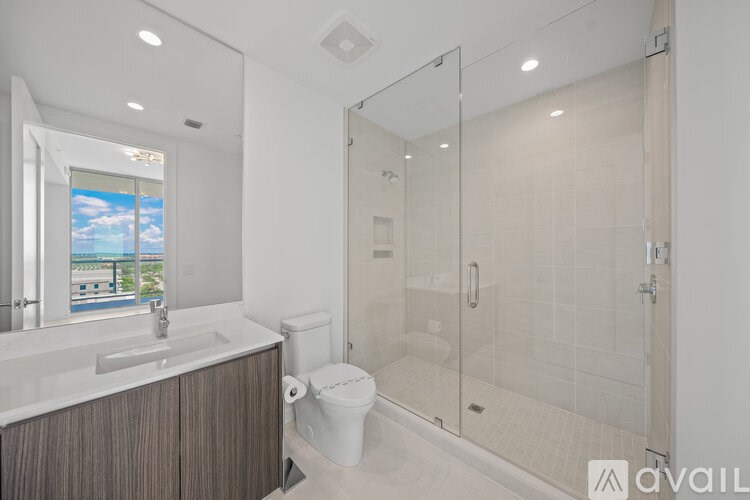 A modern bathroom with a walk-in shower and a large mirror.