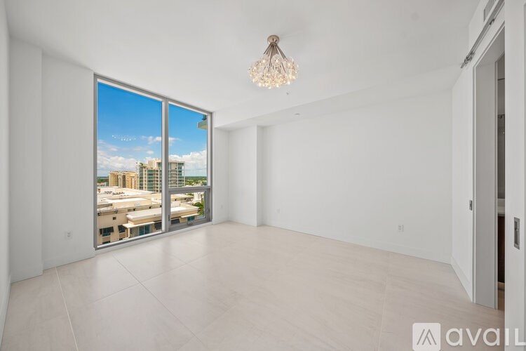 A large empty room with a view of the city through the windows.