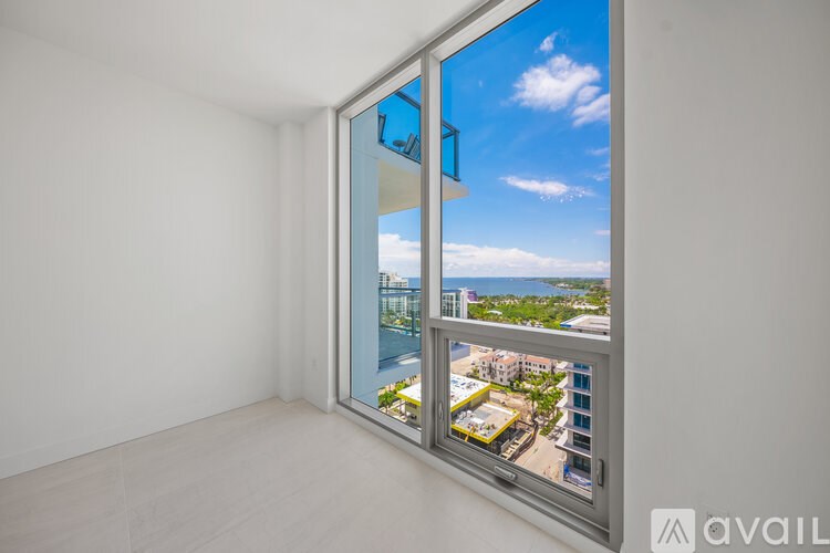 A room with a large window overlooking a cityscape.