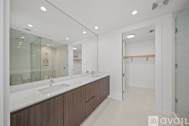 A bathroom with a sink, mirror, and wooden cabinets.