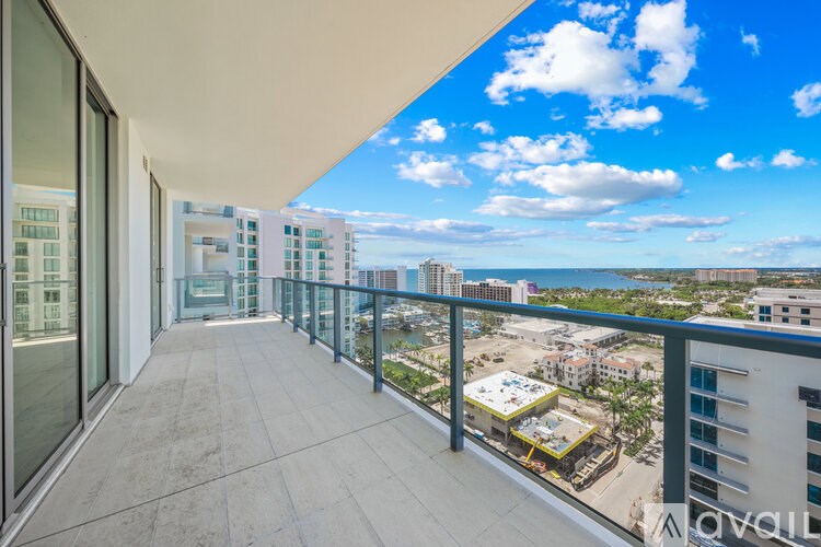 A balcony with a view of the city and the ocean.