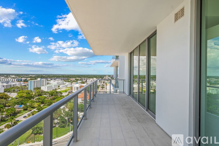 A balcony with a metal railing overlooks a cityscape.
