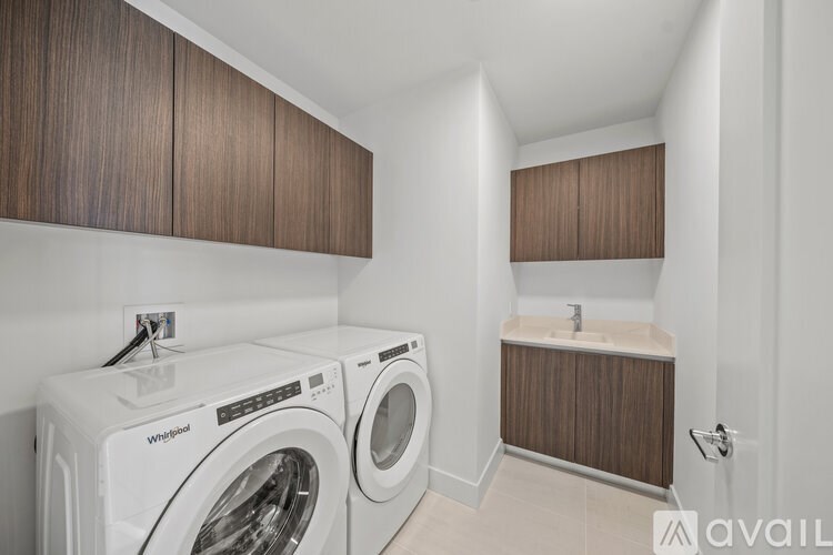 A laundry room with a washer and dryer and a sink.