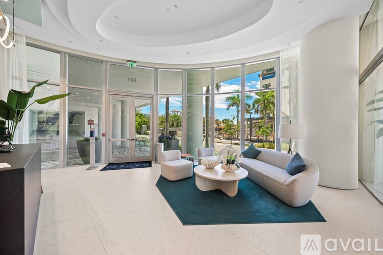 A modern living room with a large window overlooking a tropical landscape.