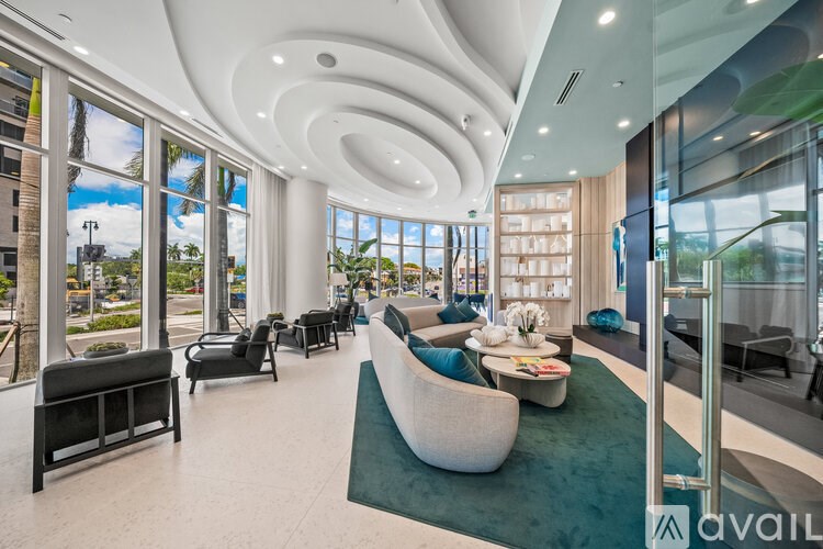 A spacious living room with a curved ceiling design and large windows overlooking a cityscape.
