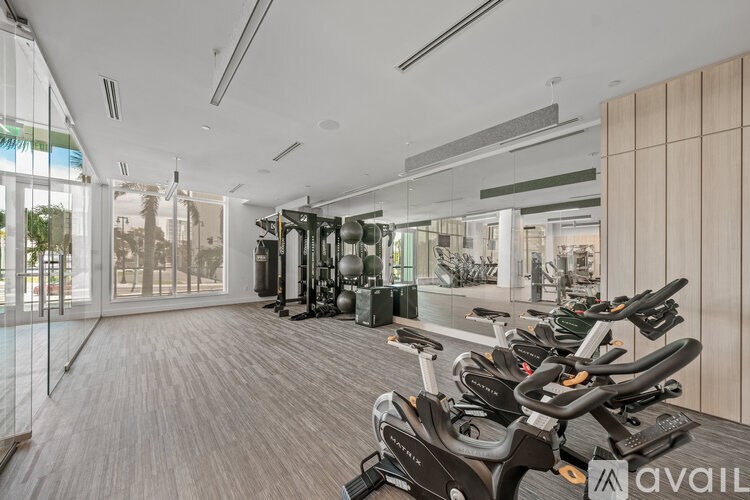 A gym with a variety of exercise equipment including treadmills, stationary bikes, and weight machines.