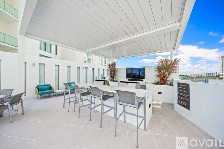 A white patio with chairs and a table is shown.