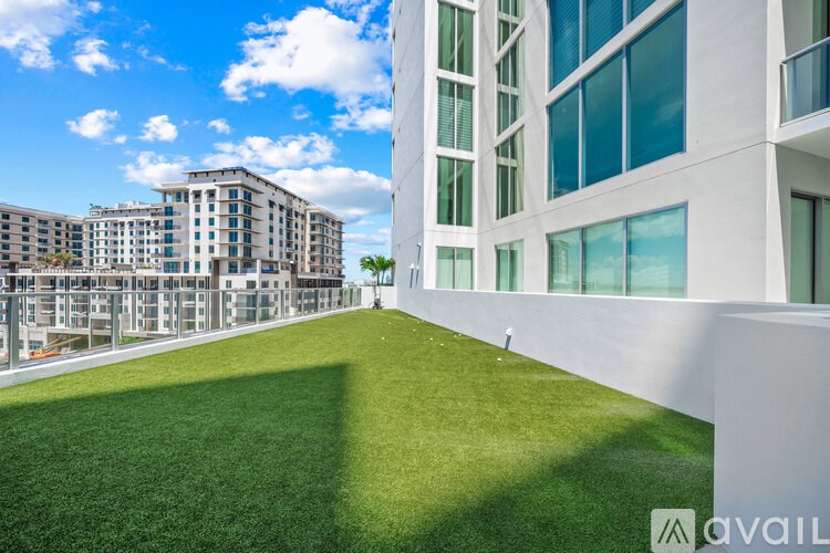 A white building with a green lawn in front.
