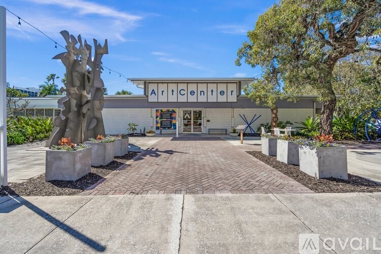 The Art Center building has a white facade and is surrounded by trees and planters.