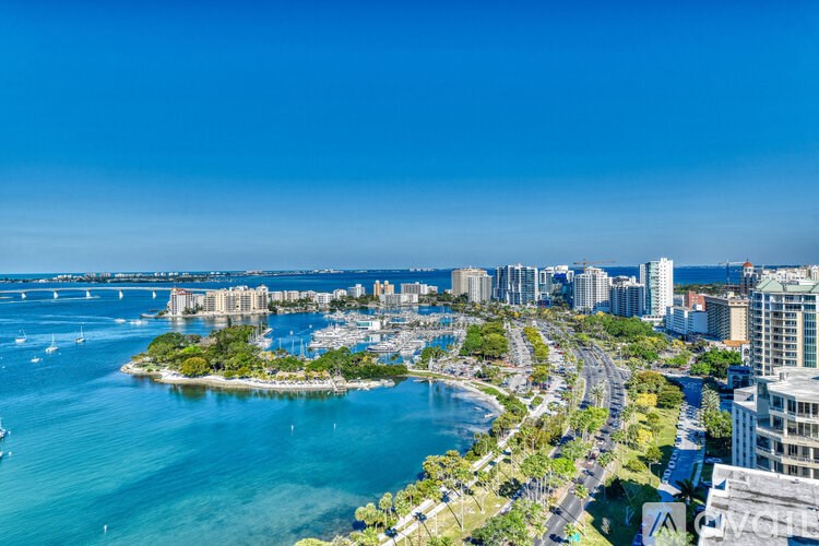 A cityscape with a body of water and a bridge in the background.