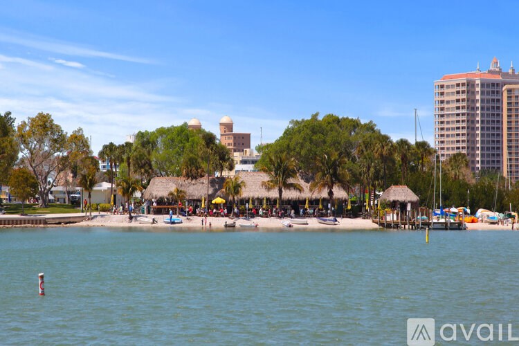 A beach with a large body of water and a building in the background.