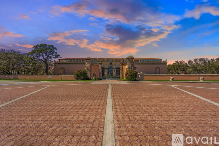 A large building with a circular patterned walkway in front of it.