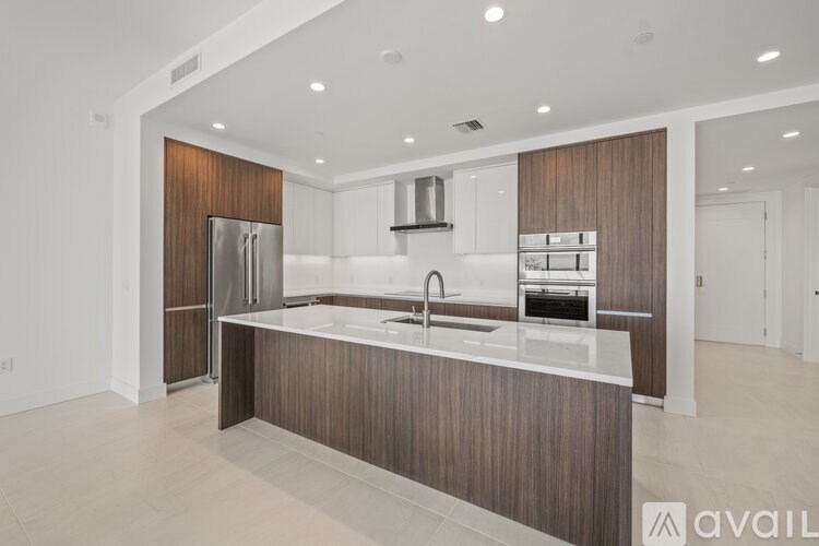 A modern kitchen with a wooden backsplash and stainless steel appliances.