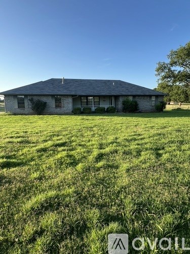 A house with a grassy field in front of it.