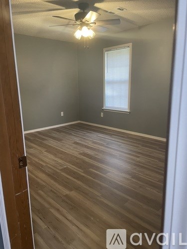A room with wooden flooring and a ceiling fan.