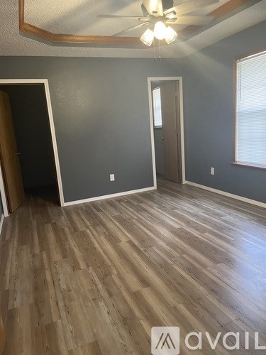 A room with wooden flooring and a ceiling fan.