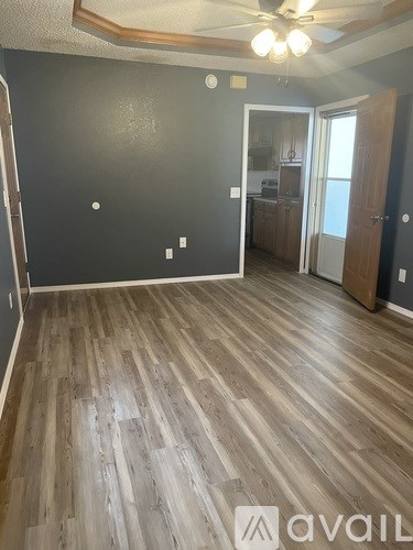A room with wooden flooring and a ceiling fan.