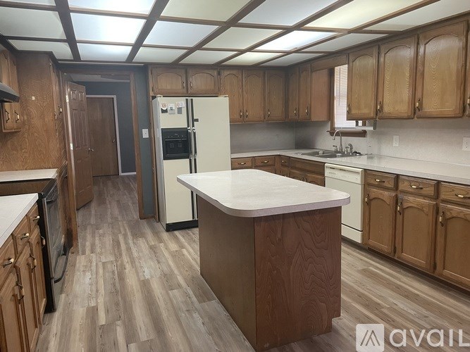 A kitchen with wooden cabinets and a white island.
