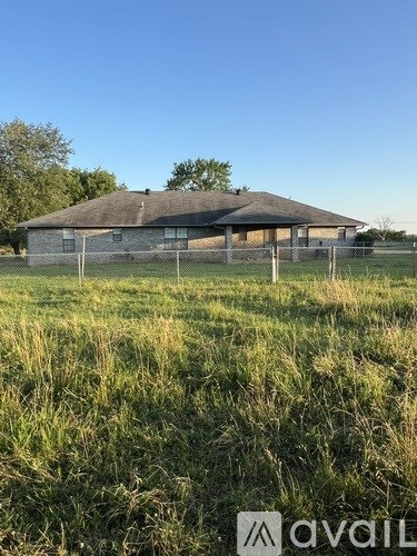 A large, old building with a metal roof and a fence in front of it.