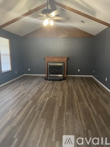 A room with a fireplace and wood flooring.